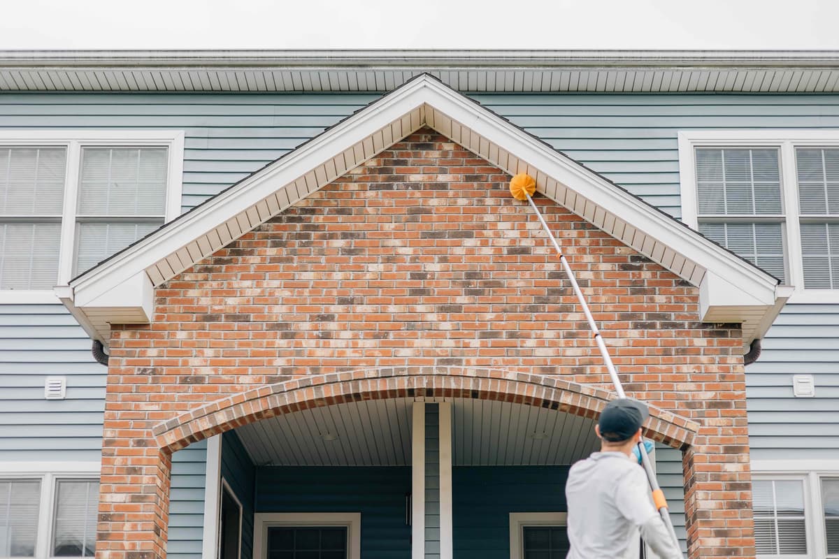 Ruva Pest Control technician performing exterior treatment on a home in Mansfield, MA